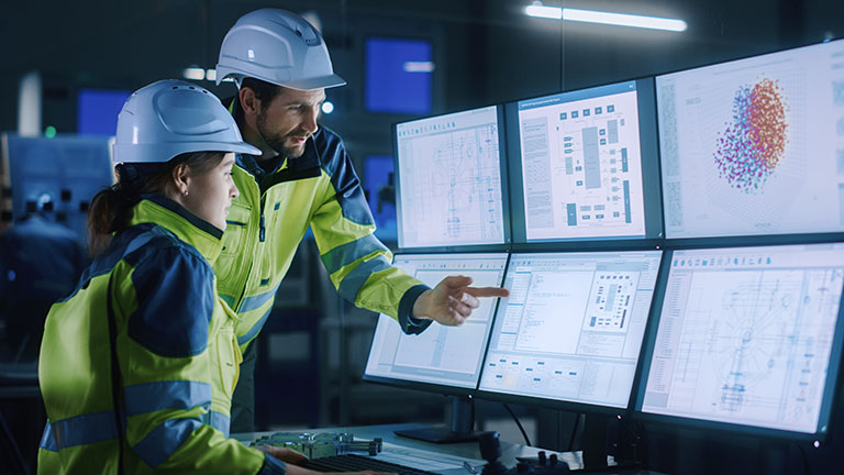 Modern factory engineers looking at computer screens