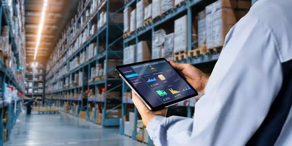 A warehouse worker looking at analytics on a tablet