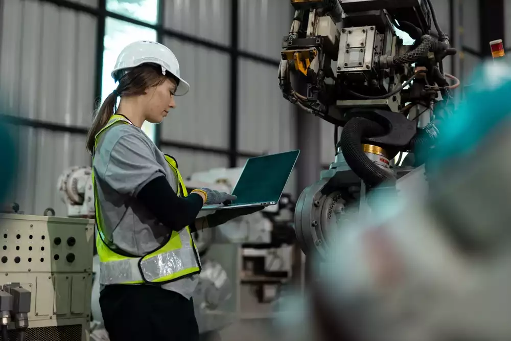 An engineer on a factory floor reviewing data