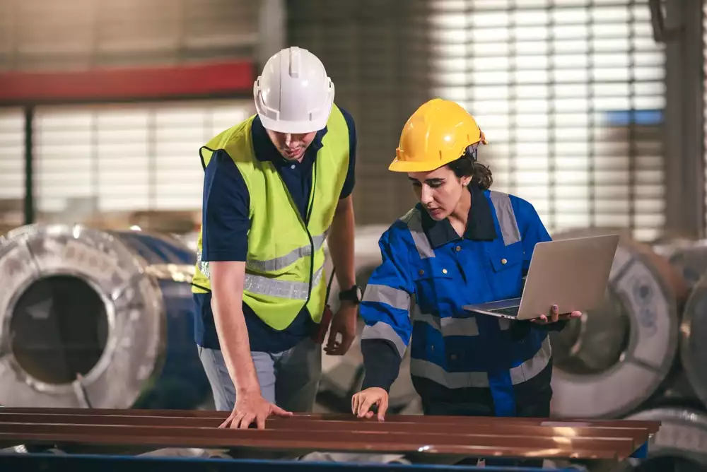 Two engineers checking the manufacturing factory equipment and data