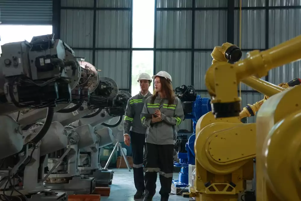 Engineers checking robotic arms for a factory