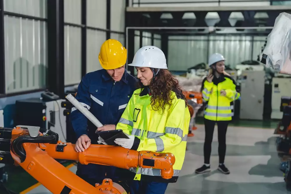 Engineers consulting a tablet on the factory floor