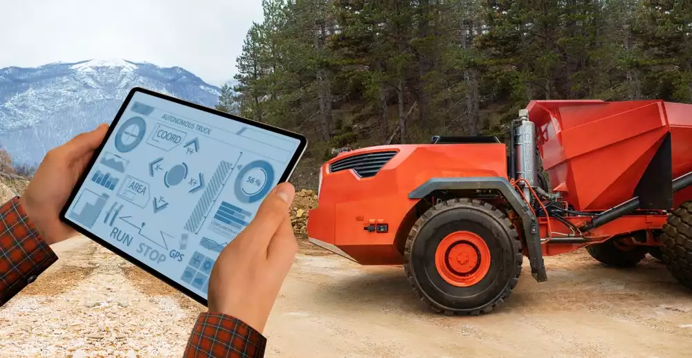 Man using a tablet in front of mining truck