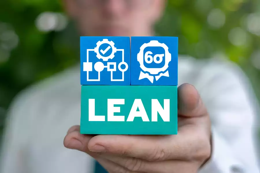 Man holding three blocks that represent lean manufacturing