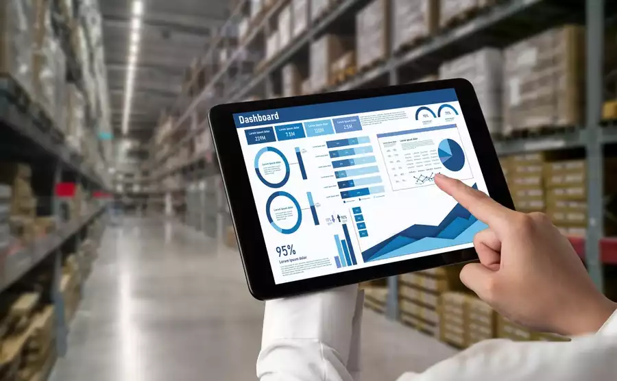 Factory setting, worker checking up on an automation dashboard